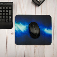 A lifestyle image of a classic mousepad on a wooden table with a computer mouse and keyboard.