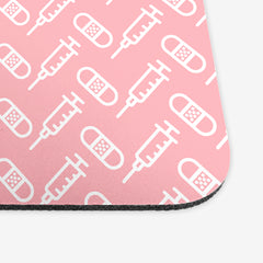 A close-up of the pink classic mousepad with a white pattern of bandages and vaccines