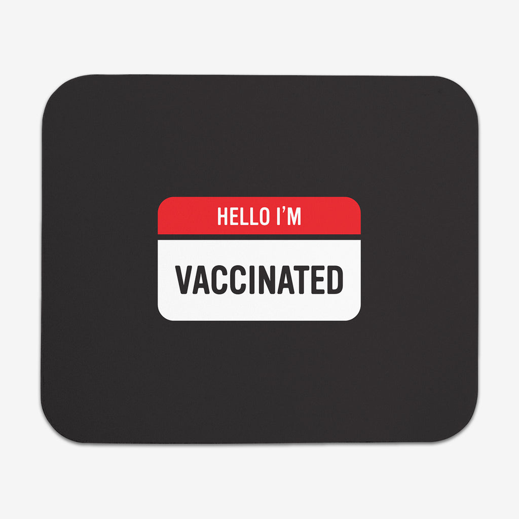 A black classic mousepad with a red and white label at the center. The red part of the label says "Hello I'm" in white text. The white part of the label reads "Vaccinated" in black text.