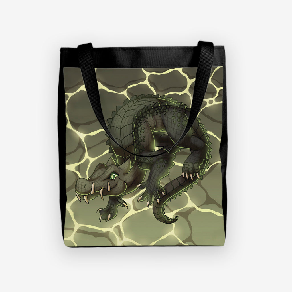 The front of the day tote of Kaprosuchus by Ian Haramaki. A large alligator like dinosaur sits curled up in the center of this tote. 