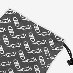 A close-up of a grey dice bag with a white pattern of bandages and vaccines.