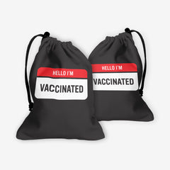 A front and back side of a black dice bag with a red and white label at the center. The red part of the label reads “Hello I’m” in white text. The white part of the label reads “Vaccinated” in black text.