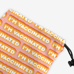 A close-up of a pink dice bag with an orange and white bubble text pattern. The text that reads “I’m Vaccinated” is in white. Each of these has orange behind them, from the lightest shade to the darkest shade.