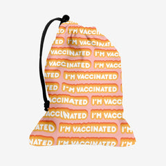 A pink dice bag with an orange and white bubble text pattern. The text that reads “I’m Vaccinated” is in white. Each of these has orange behind them, from the lightest shade to the darkest shade.
