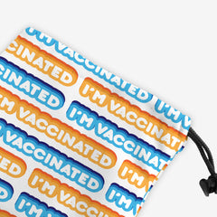 A close-up of a white dice bag with an orange, blue, and white bubble text pattern. The text that reads “I’m Vaccinated” is in white. Each of these has orange or blue behind them, from the lightest shade to the darkest shade.
