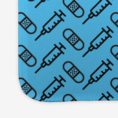 A close-up of the blue large gaming mousepad with a black pattern of bandages and vaccines