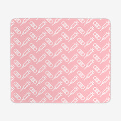 A pink large gaming mousepad with a white pattern of bandages and vaccines