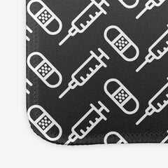 A close-up of the grey extra large gaming mousepad with a white pattern of bandages and vaccines