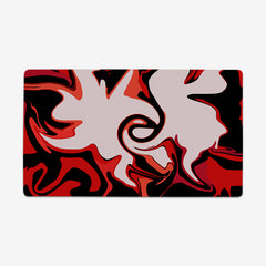 The playmat Paint Splash by Carbon Beaver. Abstract red, black, and pink shapes swirl around each other. 