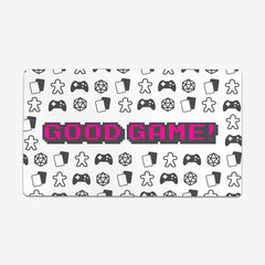 Pink version of Good Game by Inked Gaming. Dice, cards, gaming controllers, and tokens make a pattern around text that says "Good Game" in the center of this playmat.